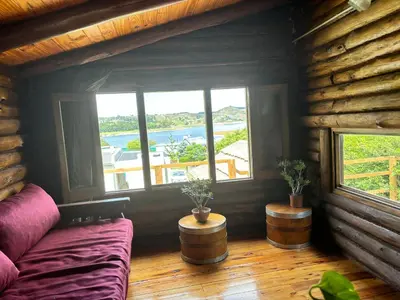 a living room with a couch and two windows at La Casa de Conco in La Estancia