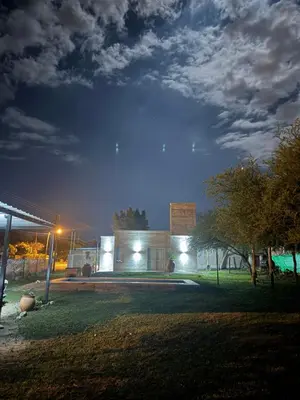 a building with lights on in a yard at night at SuiteMilSueños in Mina Clavero
