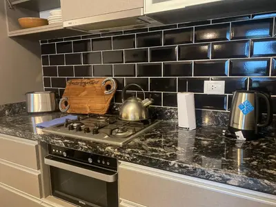 a kitchen counter with a stove and a tea kettle at Dpto 1 Dormitorio de categoria in Villa Carlos Paz