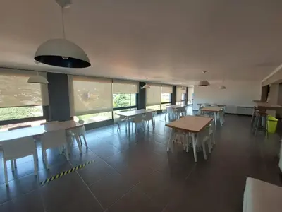 a dining room with tables and chairs and windows at Dpto 1 Dormitorio de categoria in Villa Carlos Paz