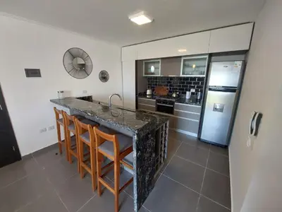 a kitchen with a counter and a refrigerator at Dpto 1 Dormitorio de categoria in Villa Carlos Paz