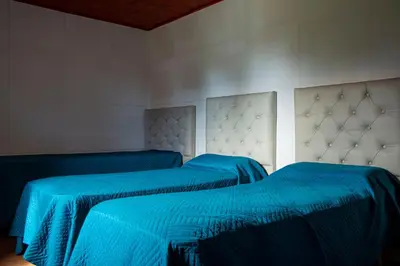 two beds in a room with blue sheets at Potrero de Garay Los Espinillos in Potrero de Garay
