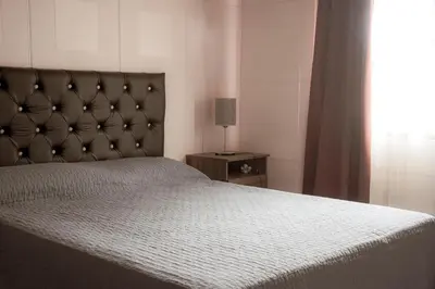 a bedroom with a bed with a headboard and a lamp at Potrero de Garay Los Espinillos in Potrero de Garay
