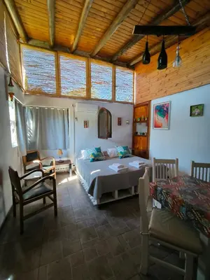 a bedroom with two beds and a table and chairs at Loft Campestre - Los Reartes in Los Reartes