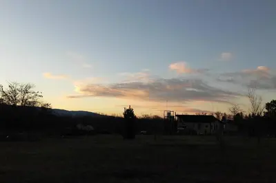 a sunset in a field with a house at Loft Campestre - Los Reartes in Los Reartes