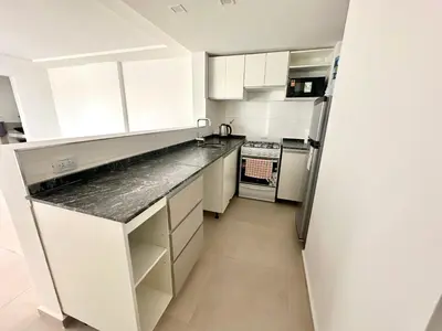 a small kitchen with white cabinets and a refrigerator at Alojamiento entero para 4 personas F in Cordoba