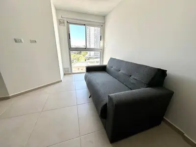 a black couch in a room with a window at Departamento p 4 personas F Gral Paz in Cordoba