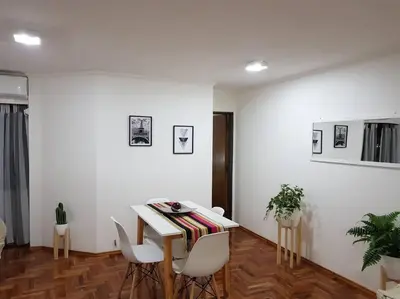 a white room with a table and white chairs at Achaval Nueva Córdoba Apartment in Cordoba