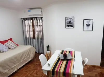 a room with a bed and a table with a table at Achaval Nueva Córdoba Apartment in Cordoba