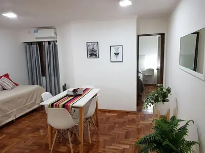 a room with a bed and a table and chairs at Achaval Nueva Córdoba Apartment in Cordoba