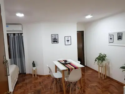 a living room with a table and white chairs at Achaval Nueva Córdoba Apartment in Cordoba