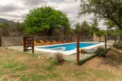 a swimming pool with chairs in a yard at Cabañas Mi Respiro in Los Molles