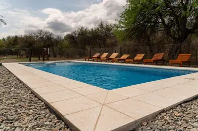 a swimming pool with chairs and a poolvisorvisor at Cabañas Mi Respiro in Los Molles