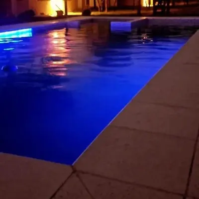 a swimming pool at night with blue illumination at Cabañas Mi Respiro in Los Molles