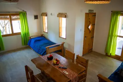a living room with a table and a bed at Cabañas Mi Respiro in Los Molles