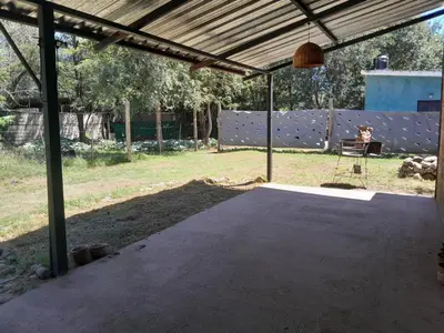 a covered patio with a person sitting on a bench at Casa Azul in Villa del Dique