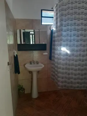 a bathroom with a sink and a shower curtain at Casa Azul in Villa del Dique