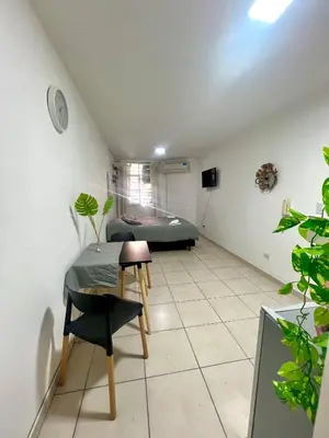 a room with two beds and a table at Departamento en el corazón de Córdoba in Cordoba