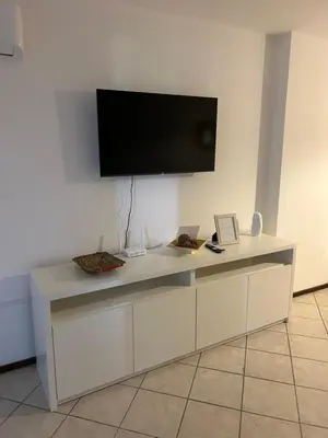 a white desk with a flat screen tv on a wall at LA MEJOR UBICACIÓN de NUEVA CÓRDOBA in Cordoba