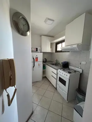 a kitchen with white appliances and a clock on the wall at LA MEJOR UBICACIÓN de NUEVA CÓRDOBA in Cordoba