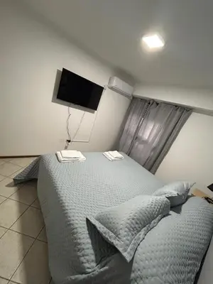 a bedroom with a bed and a flat screen tv at LA MEJOR UBICACIÓN de NUEVA CÓRDOBA in Cordoba