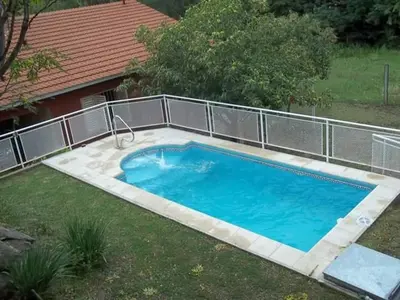 a small swimming pool in a yard next to a house at Casa Con Pileta Exclusiva a 50 mtrs Rio in Villa Carlos Paz