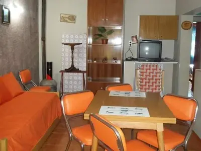 a living room with a table and chairs and a tv at Casa Con Pileta Exclusiva a 50 mtrs Rio in Villa Carlos Paz