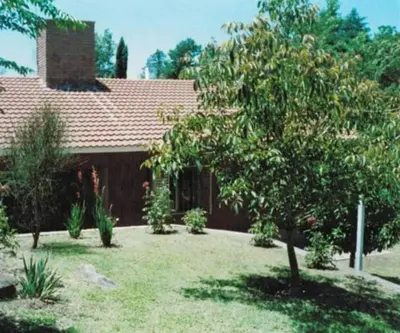 a house with a tree in the yard at Casa Con Pileta Exclusiva a 50 mtrs Rio in Villa Carlos Paz