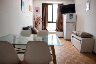 a living room with a glass table and chairs at El diez 1 dorm con COCHERA in Cordoba
