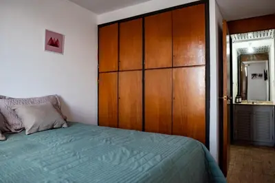 a bedroom with a bed and a wooden cabinet at El diez 1 dorm con COCHERA in Cordoba