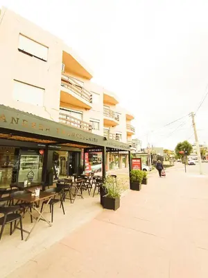 a restaurant with tables and chairs outside of a building at Edificio en Avenida Libertad in Villa Carlos Paz
