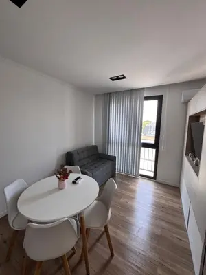 a living room with a table and chairs and a couch at Carlos paz resort premium in Villa Carlos Paz