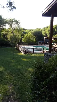 a fence next to a pool in a yard at Refugio de las Sierras in Villa General Belgrano