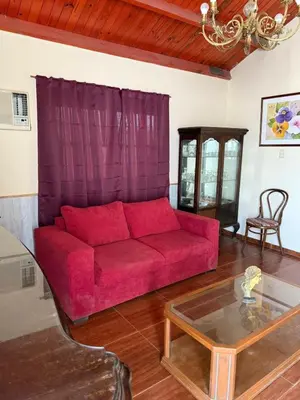 a living room with a red couch and a table at Casa feliza in Villa Dolores