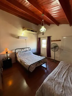 a bedroom with two beds and a wooden ceiling at Casa feliza in Villa Dolores