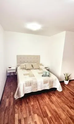 a bedroom with a bed and a wooden floor at Departamento en la Docta in Cordoba
