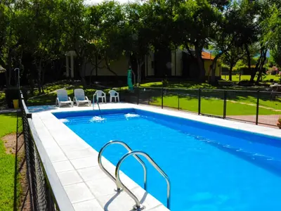 a swimming pool with chairs next to a fence at Apart Entrepiedras in Merlo