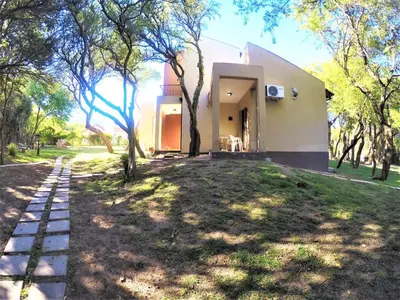 a house in the middle of a yard with trees at Apart Entrepiedras in Merlo