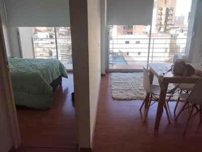 a room with a table and a bed and a table and chairs at Departamento con FERNET in Cordoba