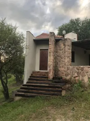 a small house with stairs leading to a door at Cabaña Tala Huasi in Villa Icho Cruz
