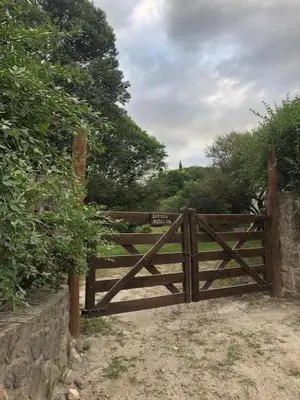 a wooden gate with a sign on top of it at Cabaña Tala Huasi in Villa Icho Cruz