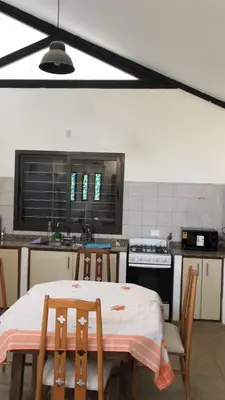 a kitchen with a table and chairs and a stove at Cabaña Tala Huasi in Villa Icho Cruz