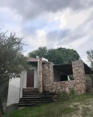 a small stone house with stairs and a door at Cabaña Tala Huasi in Villa Icho Cruz