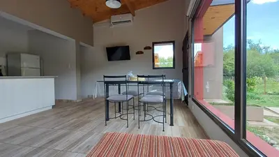 a kitchen with a table and stools in a room at Refugio Serrano in Merlo