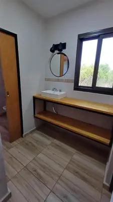 a bathroom with a sink and a mirror and a window at Refugio Serrano in Merlo