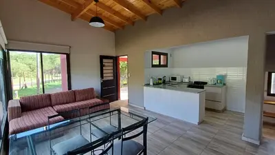 a kitchen and living room with a couch and a table at Refugio Serrano in Merlo
