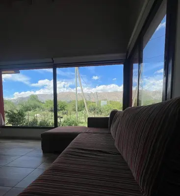 a living room with a couch and a large window at Refugio Serrano in Merlo