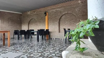a room with black chairs and a brick wall at BALCON De LA SIERRA in Las Calles
