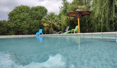 an empty swimming pool with an umbrella and chairs at BALCON De LA SIERRA in Las Calles