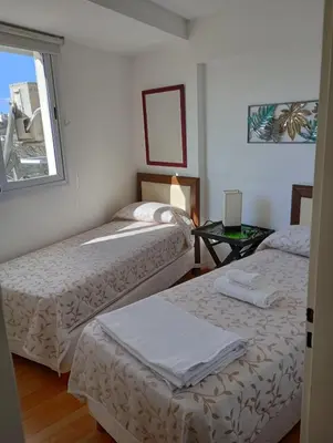 two beds in a room with a window at Departamento Polanco Tower in Cordoba